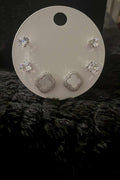 Clover & Stud Set featuring silver-tone metal clover-shaped earrings and clear crystal stud earrings on a white holder.