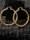 Gold-tone textured hoop earrings with a twisted pattern, shiny finish, a classic round shape, representing Bambi's style.