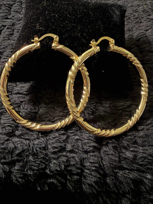 Gold-tone textured hoop earrings with a twisted pattern, shiny finish, a classic round shape, representing Bambi's style.