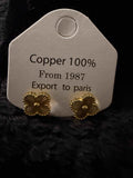 Gold Clovers Earrings in gold-tone copper with textured four-leaf clover design on a display card labeled Copper 100%